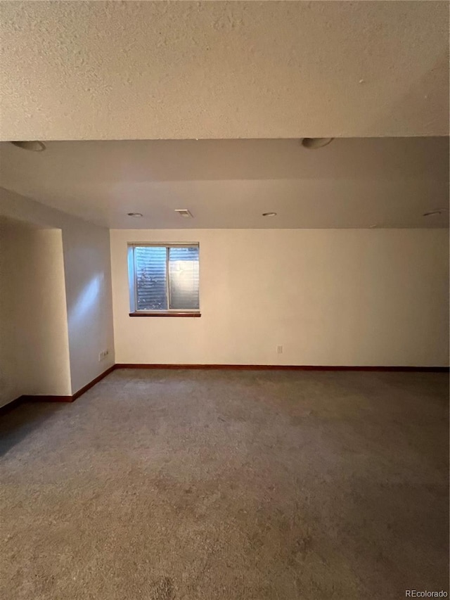 unfurnished room with carpet floors and a textured ceiling