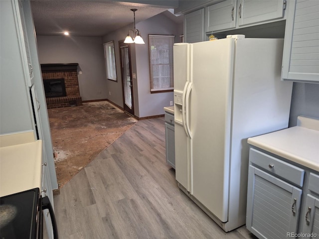 2477 S Oakland Cir, Aurora, CO 80014 - kitchen featuring white refrigerator with ice dispenser, light wood-style flooring, gray cabinetry, a fireplace, and pendant lighting