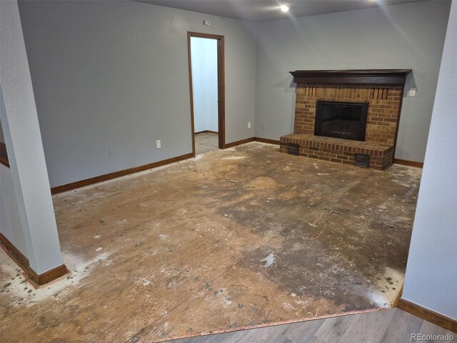 2477 S Oakland Cir, Aurora, CO 80014 - unfurnished living room featuring a brick fireplace and baseboards