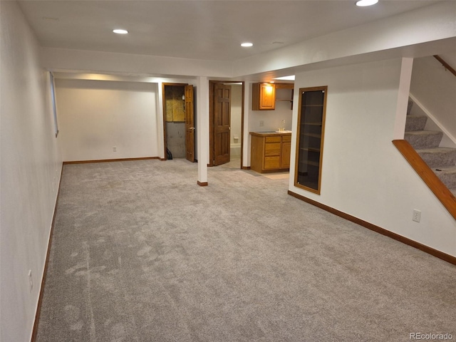 2477 S Oakland Cir, Aurora, CO 80014 - finished below grade area with light carpet, stairway, baseboards, and recessed lighting