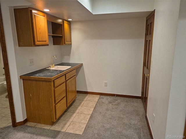 2477 S Oakland Cir, Aurora, CO 80014 - kitchen featuring a sink, light tile patterned floors, brown cabinetry, and baseboards