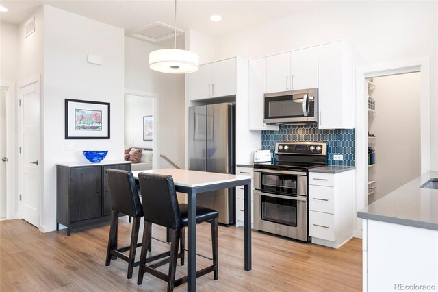 928 Cimarron Dr Unit C, Lafayette, CO 80026 - kitchen featuring stainless steel appliances, light wood-type flooring, backsplash, white cabinets, and recessed lighting