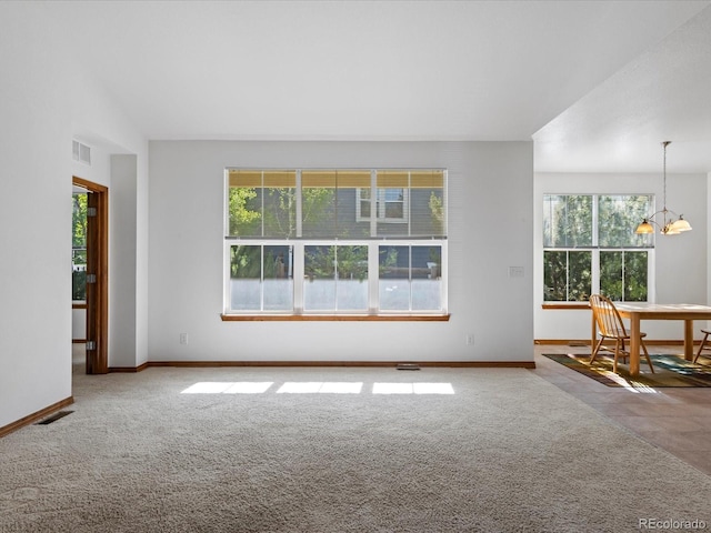 7254 S Kellerman Way, Aurora, CO 80016 - unfurnished living room featuring healthy amount of natural light, carpet, and a chandelier
