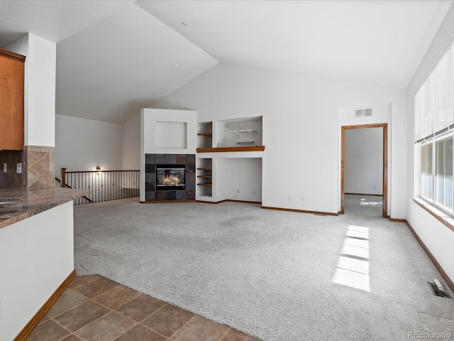 7254 S Kellerman Way, Aurora, CO 80016 - unfurnished living room featuring dark colored carpet, vaulted ceiling, a fireplace, and built in features