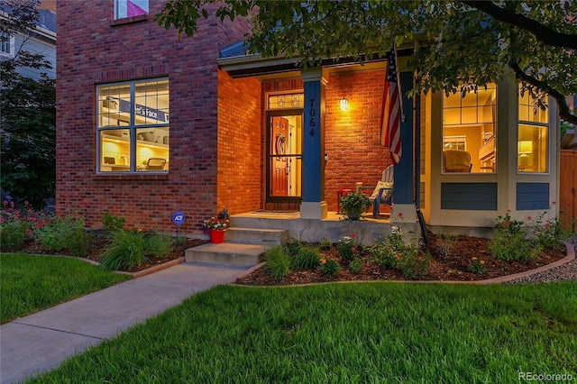7064 E 2nd Ave, Denver, CO 80220 - doorway to property with brick siding and a yard