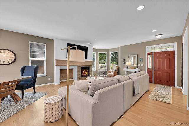 7064 E 2nd Ave, Denver, CO 80220 - living area featuring light wood finished floors, a brick fireplace, recessed lighting, and baseboards