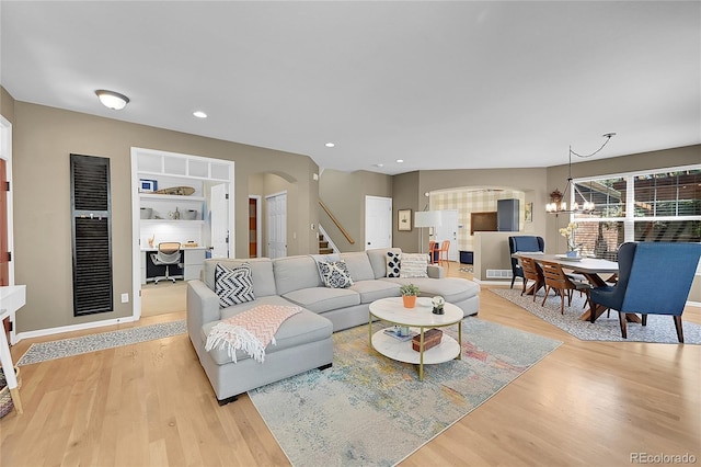 7064 E 2nd Ave, Denver, CO 80220 - living room with arched walkways, light wood-style flooring, stairs, a chandelier, and recessed lighting