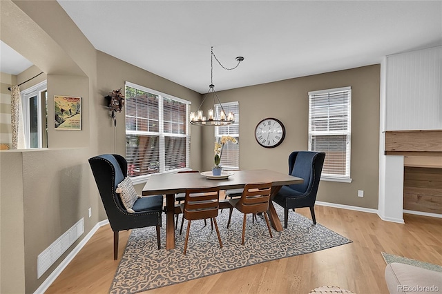 7064 E 2nd Ave, Denver, CO 80220 - dining area with light wood finished floors, baseboards, and a chandelier