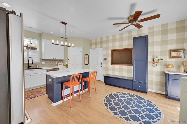 7064 E 2nd Ave, Denver, CO 80220 - kitchen with a sink, a kitchen bar, ceiling fan, wallpapered walls, and light countertops