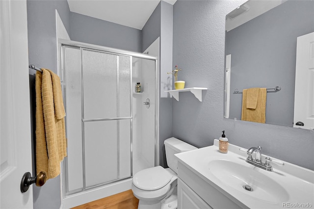 7064 E 2nd Ave, Denver, CO 80220 - full bath featuring a stall shower, toilet, vanity, a textured wall, and wood finished floors