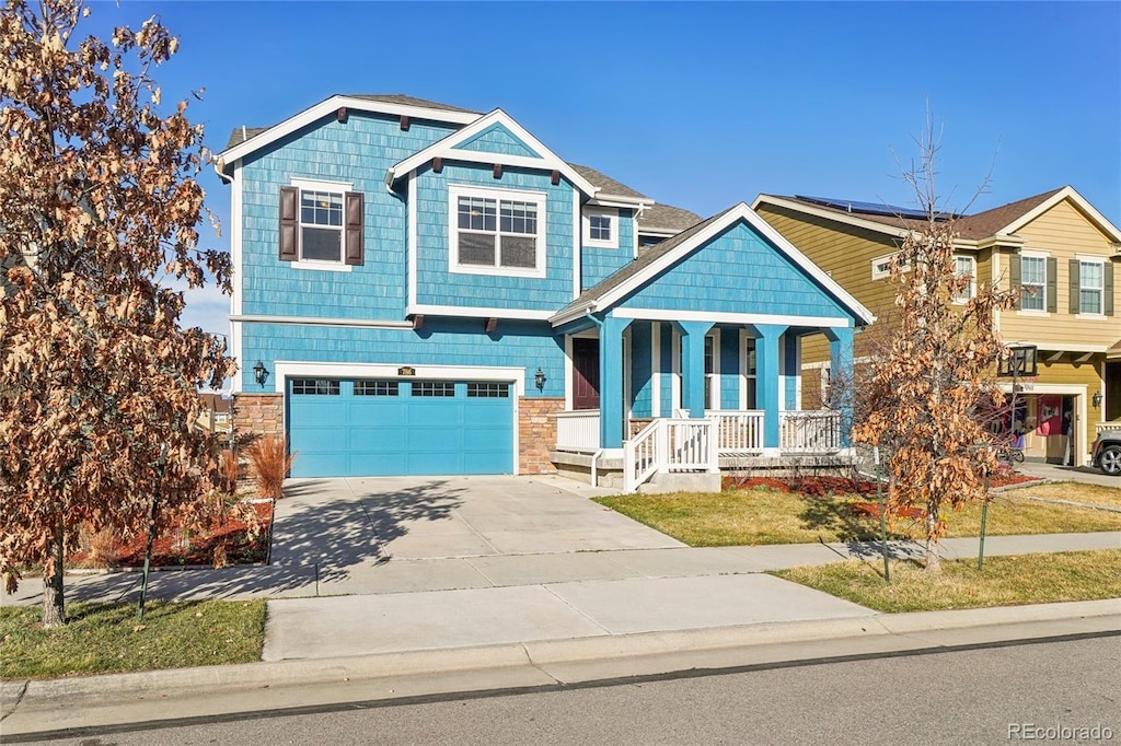 craftsman inspired home featuring a garage, roof mounted solar panels, a porch, and concrete driveway
