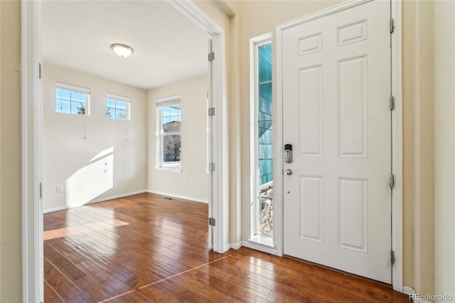 foyer entrance featuring baseboards and wood-type flooring