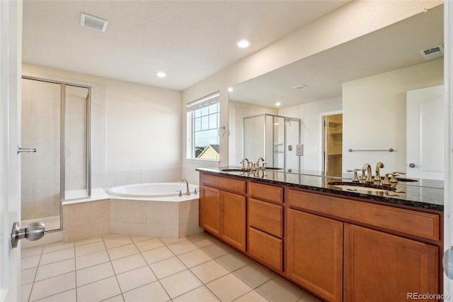 bathroom featuring visible vents, tile patterned floors, a stall shower, a bath, and a sink