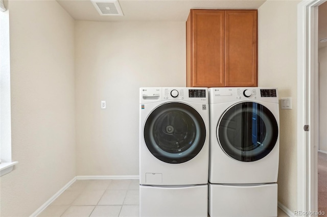 laundry room with visible vents, baseboards, light tile patterned flooring, separate washer and dryer, and cabinet space