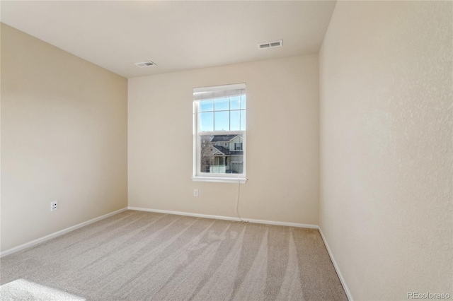 empty room with visible vents, light carpet, and baseboards