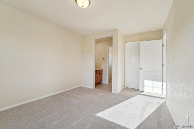 unfurnished bedroom featuring light colored carpet and baseboards