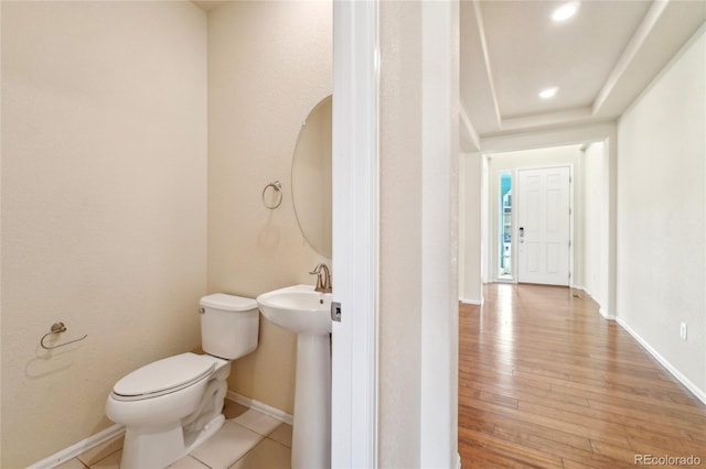 bathroom featuring baseboards, toilet, recessed lighting, wood finished floors, and a sink