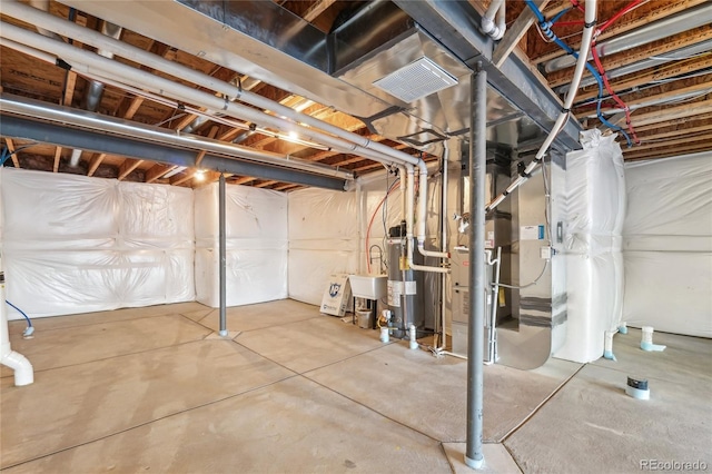 unfinished basement featuring visible vents and water heater