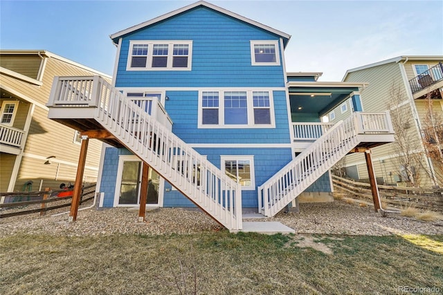 rear view of house featuring stairway, a wooden deck, and fence