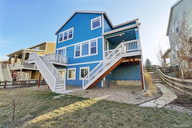 back of property with stairs, a deck, and a yard