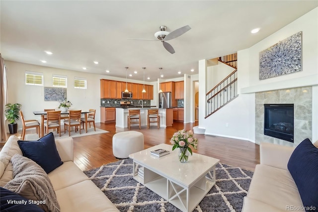 living room with stairway, recessed lighting, wood finished floors, and ceiling fan