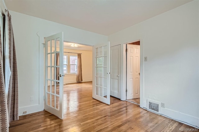 unfurnished room with light hardwood / wood-style floors and french doors