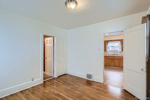 unfurnished bedroom featuring sink and light wood-type flooring