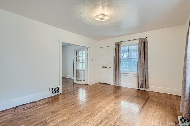 interior space with light wood-type flooring and a textured ceiling