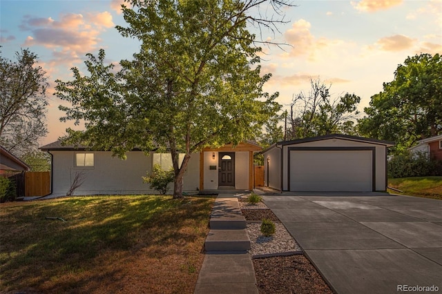 view of front facade with a garage, an outdoor structure, and a yard