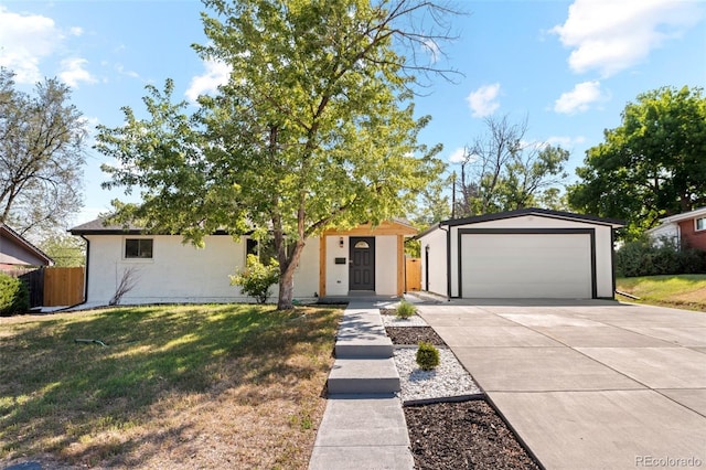 single story home featuring a garage, a front lawn, and an outdoor structure