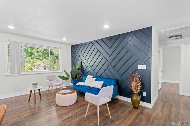 living area with wood-type flooring and a textured ceiling