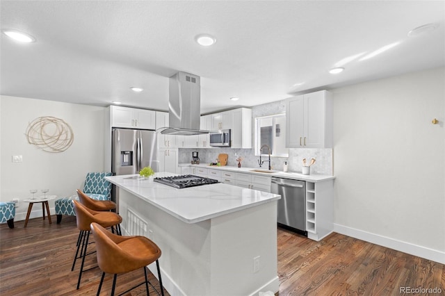 kitchen with white cabinets, sink, island exhaust hood, and appliances with stainless steel finishes