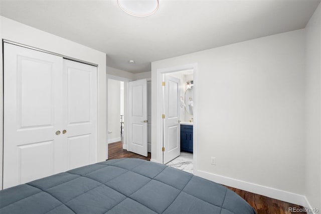 bedroom with ensuite bathroom, a closet, and hardwood / wood-style flooring