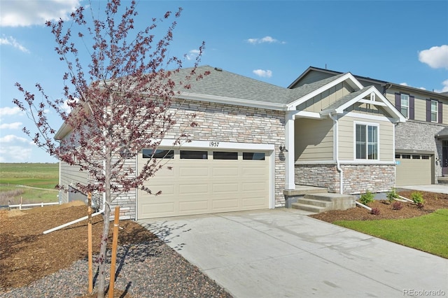 1957 S Coolidge Way, Aurora, CO 80018 - view of front of property with stone siding, driveway, board and batten siding, and an attached garage
