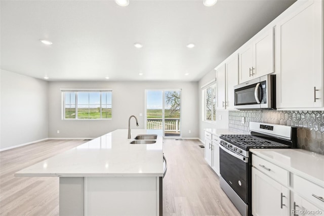 1957 S Coolidge Way, Aurora, CO 80018 - kitchen with a sink, appliances with stainless steel finishes, light wood-type flooring, open floor plan, and recessed lighting