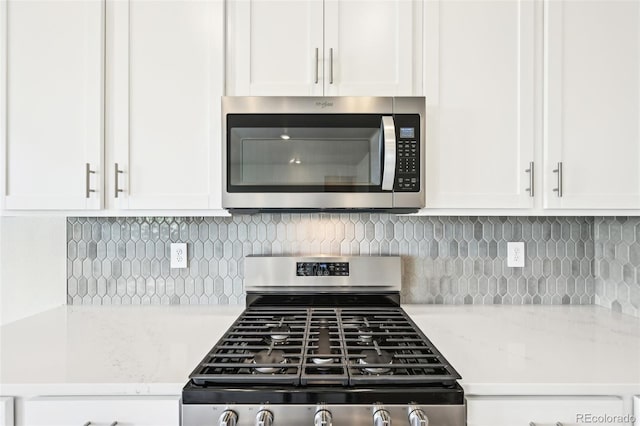 1957 S Coolidge Way, Aurora, CO 80018 - kitchen featuring stainless steel appliances, white cabinetry, and backsplash