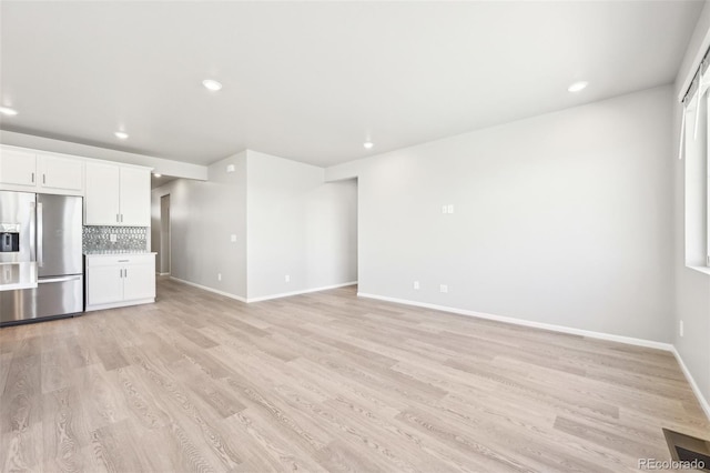 1957 S Coolidge Way, Aurora, CO 80018 - unfurnished living room with light wood-style flooring, baseboards, and recessed lighting