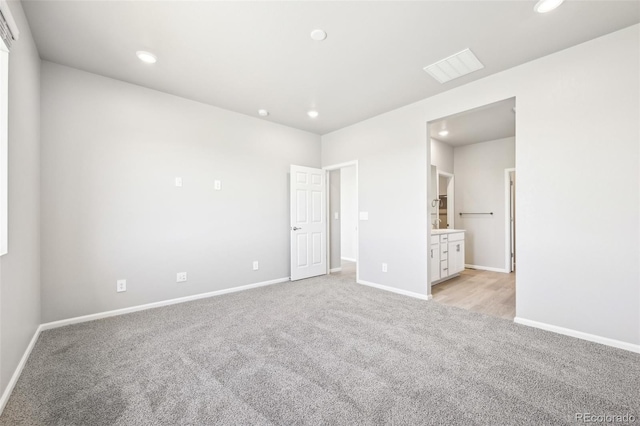 1957 S Coolidge Way, Aurora, CO 80018 - unfurnished bedroom featuring light carpet, baseboards, recessed lighting, and connected bathroom