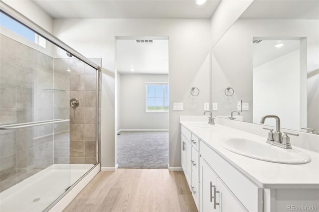 1957 S Coolidge Way, Aurora, CO 80018 - full bath featuring double vanity, wood finished floors, tiled shower, baseboards, and recessed lighting