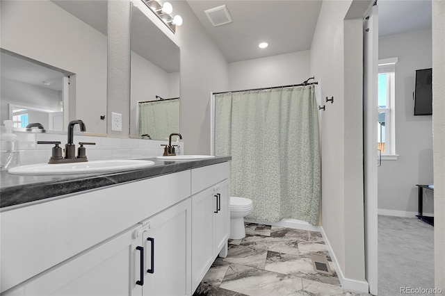 503 Bobcat Ct, Wiggins, CO 80654 - full bath featuring double vanity, toilet, a shower with curtain, and baseboards