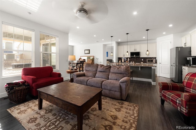 living room with dark hardwood / wood-style flooring and ceiling fan