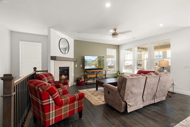 living room featuring a tile fireplace and ceiling fan