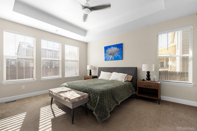 bedroom with carpet floors, a raised ceiling, and ceiling fan