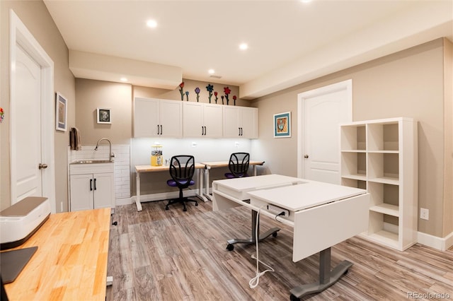 interior space with sink, built in desk, and light hardwood / wood-style flooring