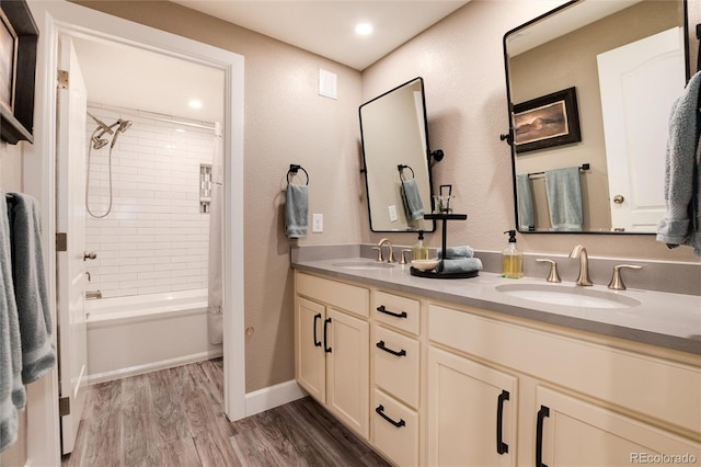 bathroom featuring vanity, wood-type flooring, and tiled shower / bath