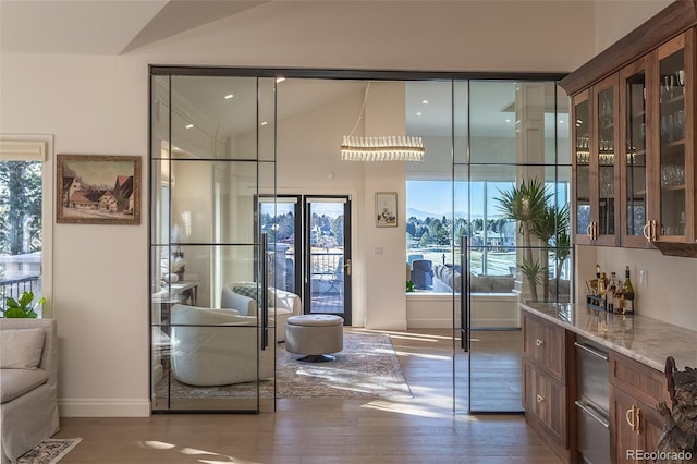 interior space with lofted ceiling, baseboards, and wood finished floors