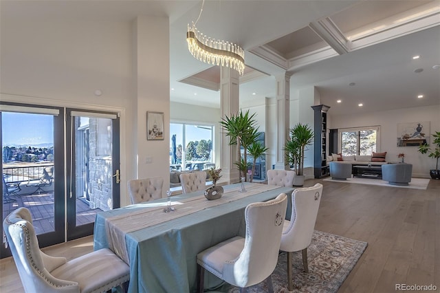 dining area featuring light wood-type flooring, a healthy amount of sunlight, decorative columns, and recessed lighting