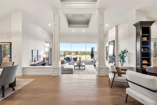 interior space featuring a decorative wall, recessed lighting, ornate columns, and wood finished floors