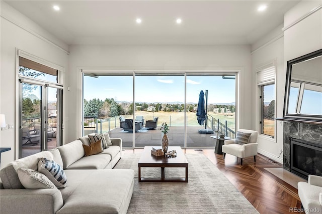 living area featuring recessed lighting, a premium fireplace, and plenty of natural light