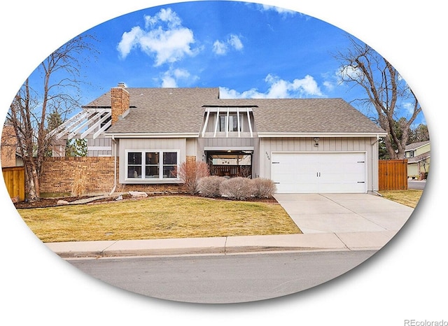 view of front of house featuring a garage, fence, driveway, board and batten siding, and a front yard